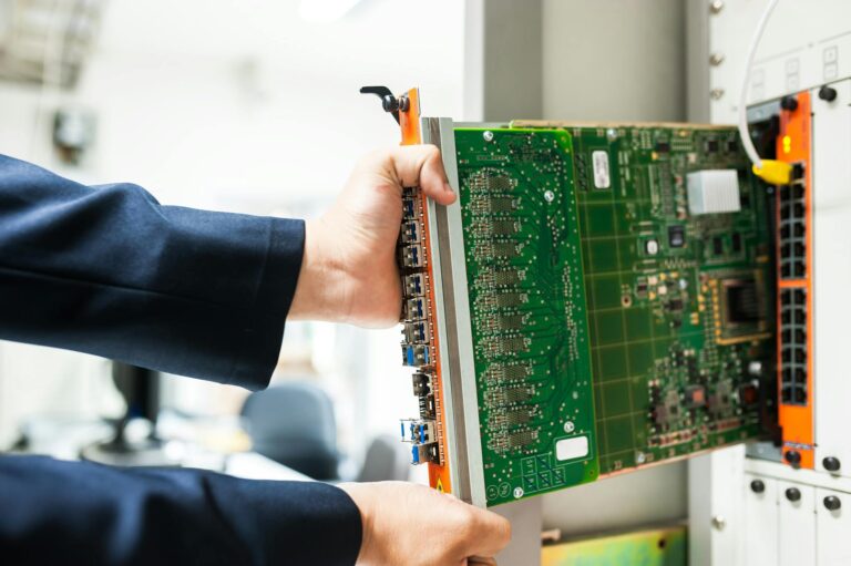 A technician inserts a circuit board into a server rack, illustrating technology and connectivity.